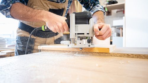 Carpenter,Holds,Milling,Machine,And,And,Working,At,Wooden,Board