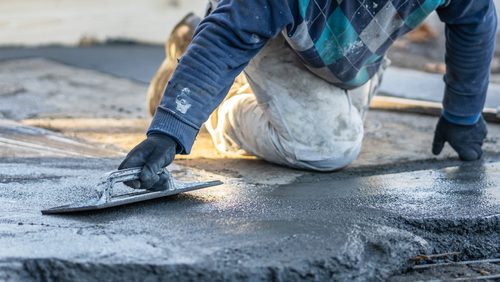 Close,Up,On,Midsection,Of,Unknown,Worker,Spreading,Concrete,Cement